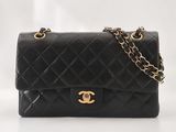 un sac Chanel noir avec des finitions dorées et une chaîne