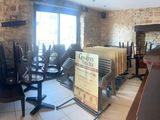 des tables et des chaises dans une pièce dotée d'un mur en pierre et d'une cheminée