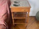 une petite table sur laquelle se trouve un bol, à côté d'un canapé