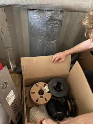 a man that is opening a box with a spool in it
