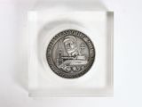 a silver coin with a picture of a lighthouse on it