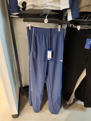 deux pantalons suspendus à un portant dans un magasin