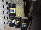 a stack of barrels sitting on a pallet next to a brick wall