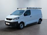 La camionnette blanche est garée dans une pièce blanche équipée d'une galerie de toit noire.