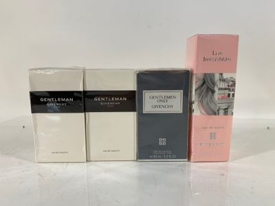 four different perfumes are lined up on a white surface