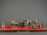 a silver figurine of a horse drawn carriage