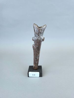 un gros plan d'une petite statue de chat posée sur un socle
