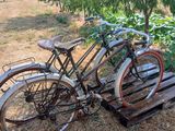two bicycles that are parked next to each other in a field