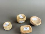 three small wooden bowls with labels on them sitting on a table