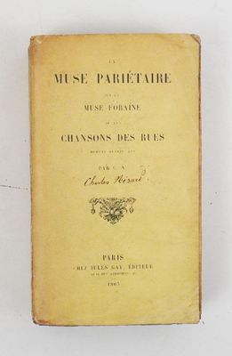 an old book sitting on top of a table next to a white wall