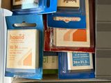 tout un tas de rouleaux de ruban adhésif de différents types dans une boîte