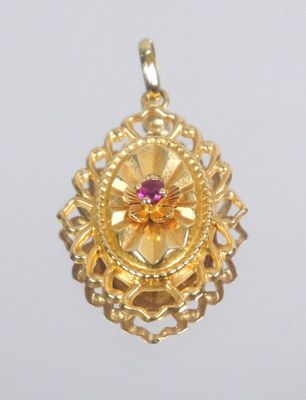 yellow gold pendant with a pink stone in the center of it