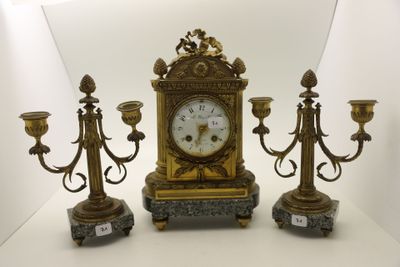 trois bougies et une horloge posées sur une table