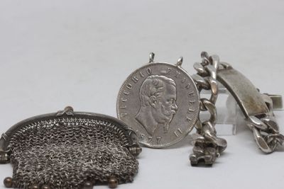 deux bijoux en argent posés sur une surface blanche