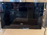 a black microwave sitting on a cardboard box in a warehouse