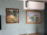 two paintings hanging on the wall above a bed