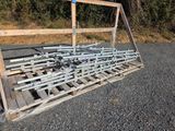 une palette en bois sur laquelle sont posées plusieurs barres métalliques