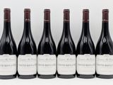 six bottles of red wine lined up in a row