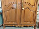 a large wooden armoire with two doors and a door handle