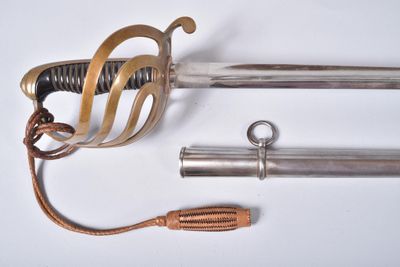 une épée avec une poignée en métal et deux autres objets posés sur une surface blanche