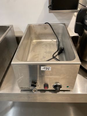 stainless steel counter top with two deep fryers and a coffee maker