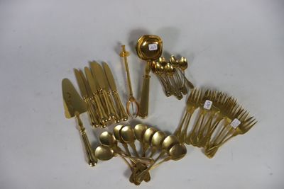 a lot of gold plated silverware on a white table
