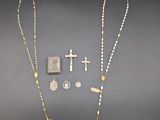 a close up of a rosary, cross, and other items on a table