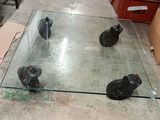 a glass table with wheels on it in a room