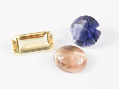 trois pierres précieuses de couleurs différentes sur une surface blanche, avec un fond blanc