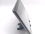 a tablet computer sitting on a stand on a white surface