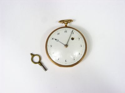 a clock and a key on a white surface
