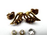 two pairs of earrings and a ring are sitting on a white surface