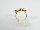 a close up of a gold ring with three pearls on it