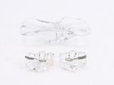 pair of clear crystal earrings and a bow on a white surface
