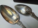 two spoons that are sitting on a table