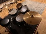 a drum set up in a recording studio with a microphone