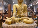 a statue of a person sitting on a table in a room
