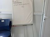 a white board on the wall next to a blue chair