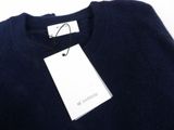 navy blue sweater with a white tag on the back of it