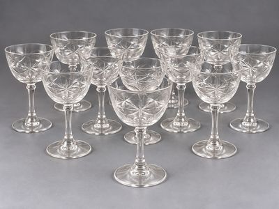 douze verres à vin transparents alignés en rang sur une surface grise