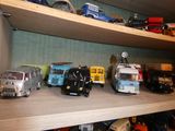 de nombreuses petites voitures et camions sur une étagère dans une pièce