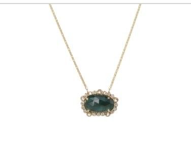un gros plan d'un collier avec une pierre verte suspendue à une chaîne