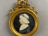an old picture of a woman in a black dress with a white hat