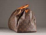 a close up of a brown louis vuitton bag on a table