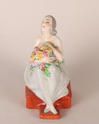 une figurine représentant une femme assise sur un banc