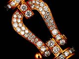 a close up of a gold and diamond broochle on a black background