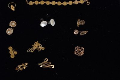 several different types of jewelry are displayed on a black surface