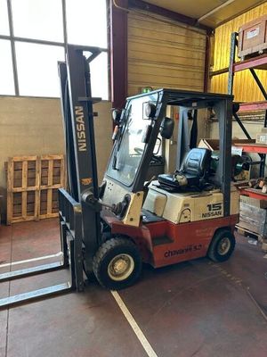 un chariot élévateur dans un entrepôt rempli de palettes et de cartons