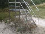 a metal stair going up the side of a dirt road