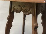 a small wooden table with carvings on the top